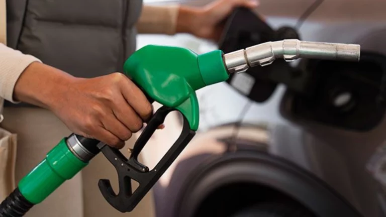 A diesel pump nozzle resting in a vehicle's fuel tank at a South African filling station forecourt with the price display visible.