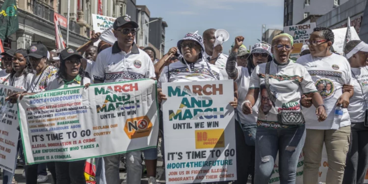 Ghana and South Africa flags against a backdrop of anti-immigrant protest fallout and diplomatic tension.