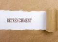 A worker reads a retrenchment notice letter at a desk in an office