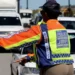 A traffic officer at a roadside checkpoint writing out an infringement notice for a driver in South Africa