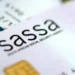 An older woman waiting in a queue outside a SASSA local office in South Africa with her identity document in hand