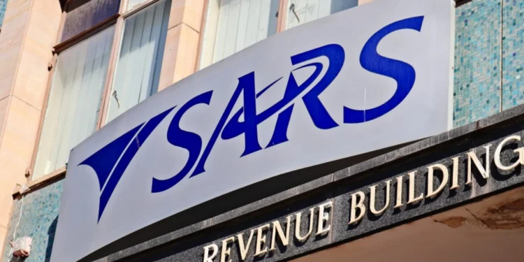 A person at a kitchen table going through tax paperwork and a laptop showing the SARS eFiling login screen
