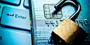 A shopper tapping a bank card on a point-of-sale card machine at a till in a South African shop