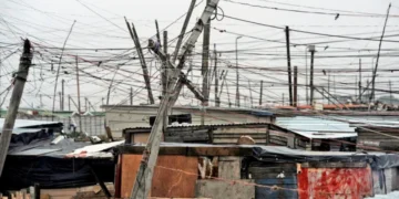 A tangle of unauthorised electrical cables strung between shacks in an informal settlement in South Africa