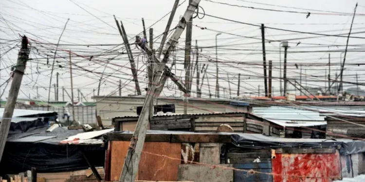 A tangle of unauthorised electrical cables strung between shacks in an informal settlement in South Africa