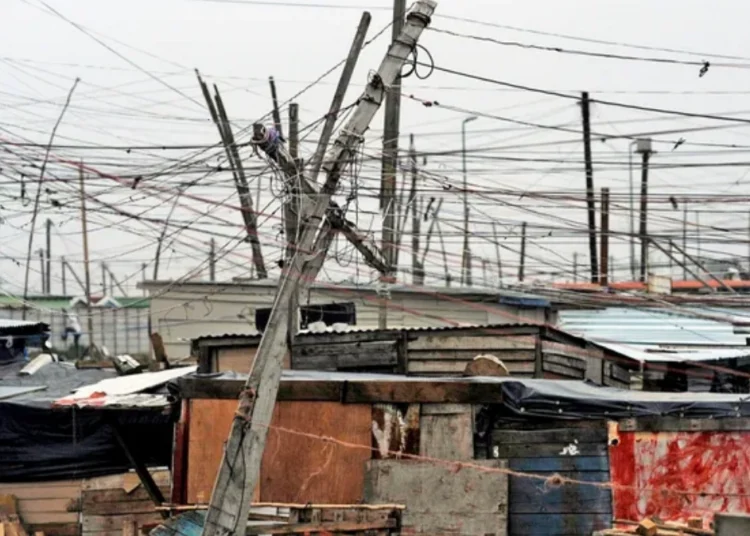 A tangle of unauthorised electrical cables strung between shacks in an informal settlement in South Africa