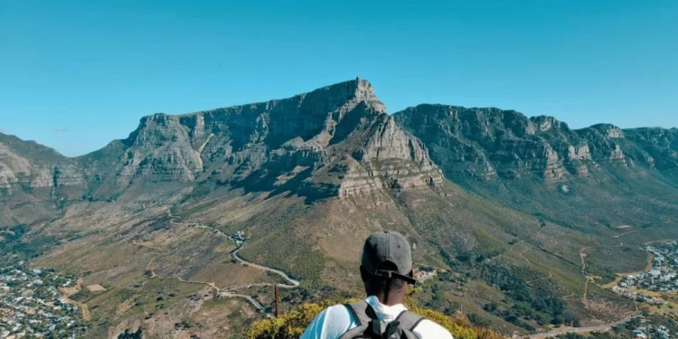A car stopped at the entrance gate of a South African national park with a game viewing road stretching ahead