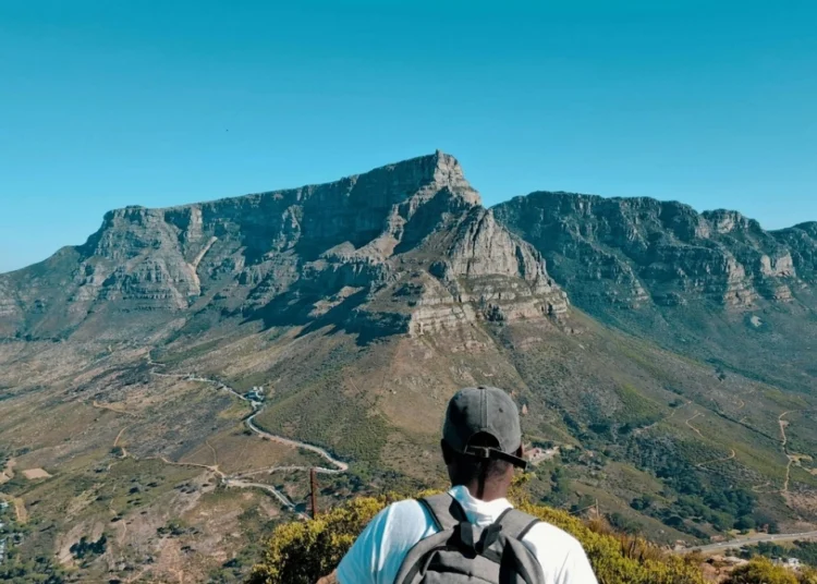 A car stopped at the entrance gate of a South African national park with a game viewing road stretching ahead