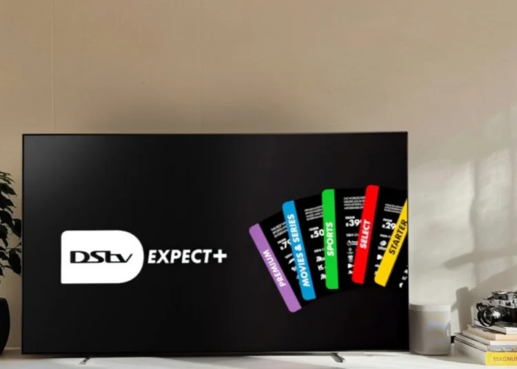 A DStv decoder and remote in front of a television showing a sports broadcast in a South African living room