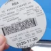A vehicle licence disc displayed on a car windscreen in Johannesburg with traffic in the background