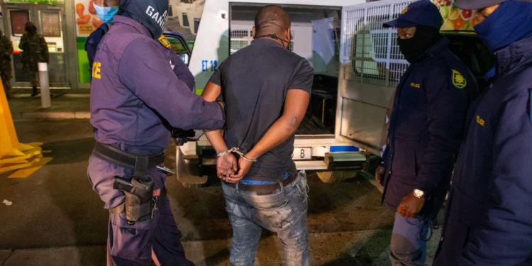 South African Police Service officers at a roadblock checking vehicles on a suburban road