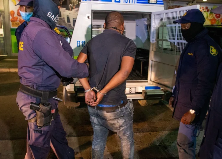 South African Police Service officers at a roadblock checking vehicles on a suburban road
