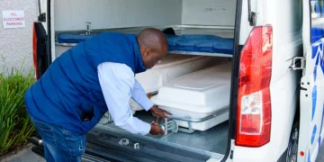 A coffin being loaded into the cargo hold of an aircraft at a South African airport