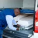 A coffin being loaded into the cargo hold of an aircraft at a South African airport