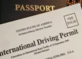 South African driving licence card and an international driving permit booklet on a table with a passport