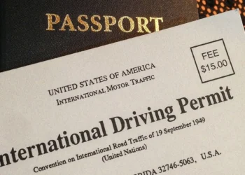 South African driving licence card and an international driving permit booklet on a table with a passport