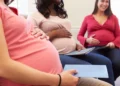 A pregnant woman filling in a UIF maternity benefit application form at a desk