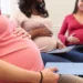 A pregnant woman filling in a UIF maternity benefit application form at a desk