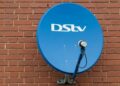 A DStv decoder and remote on a television stand in a South African living room