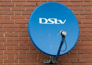 A DStv decoder and remote on a television stand in a South African living room