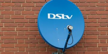 A DStv decoder and remote on a television stand in a South African living room