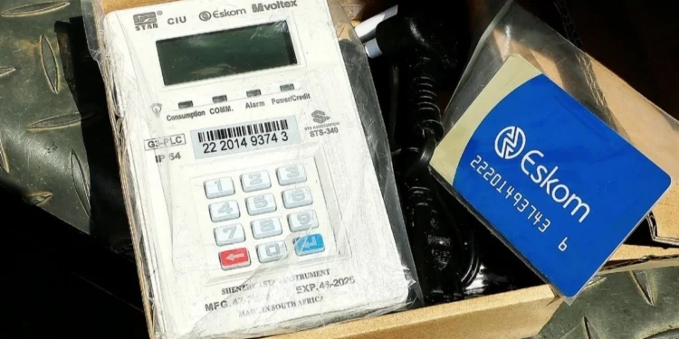 An Eskom technician fitting a prepaid smart meter to the outside wall of a house in Gauteng