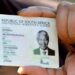A Home Affairs official handing a Smart ID card to a young applicant at a service counter